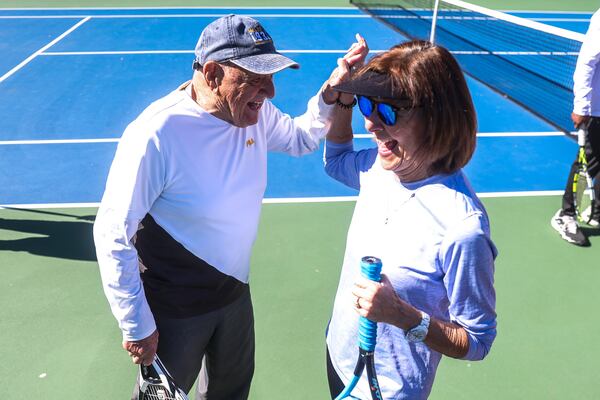 John Lamb, 90, high fives a friend on the tennis courts at Mountain Park Park in Lilburn, Ga., on Thursday, Feb. 12, 2026. Lamb says staying active is the secret to aging well. (Abbey Cutrer for the AJC)