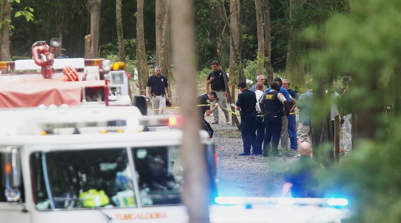 Authorities work the scene of a plane crash at a park along Robert Cardinal Airport Road across from the Tuscaloosa Regional Airport in Northport, Ala., Sunday, Aug. 14, 2016. Authorities said several people are dead following the crash of a small airplane near Tuscaloosa, Alabama. (Erin Nelson/The Tuscaloosa News via AP)