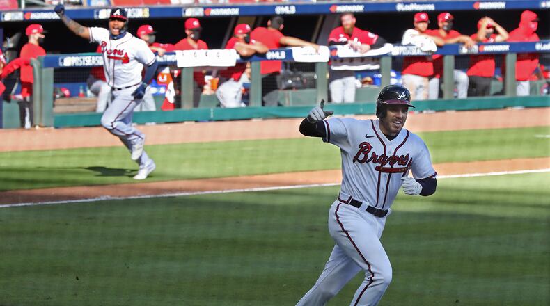 Braves pinch-runner Cristian Pache (background) heads home to score on Freddie Freeman's bloop single in the 13th inning of Game 1 of the wild card playoff series against the Cincinnati Reds Wednesday, Sept. 30, 2020, at Truist Park in Atlanta.