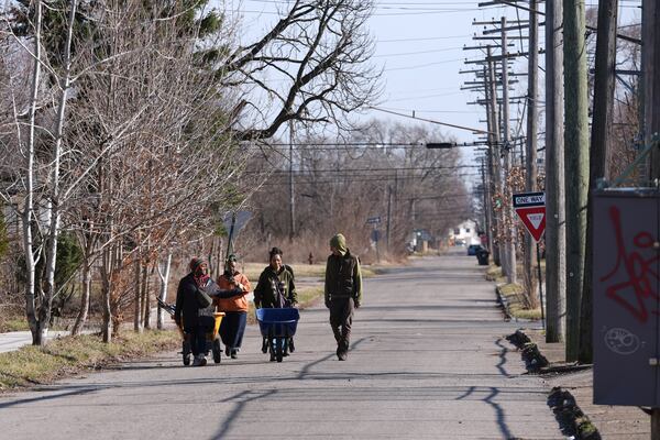 Robyn Redding, from left, Jozie Bullard, Gianna Holliday and Andrew "Birch" Kemp walk to a Arboretum Detroit parcel in Detroit, Friday, March 21, 2025. (AP Photo/Paul Sancya)