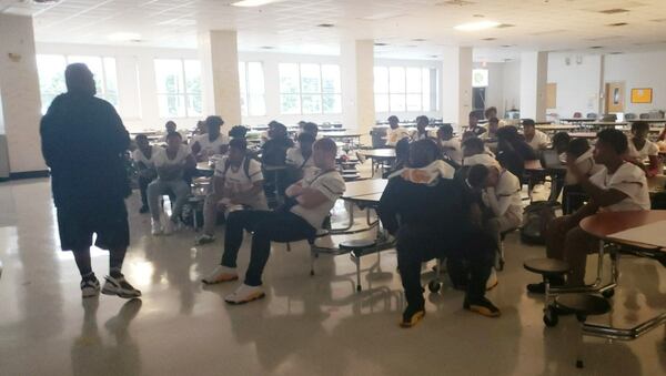 Members of the Forest Park Panthers football team gather in the cafeteria ahead of a pregame meal. The Panthers' pregame meals have been paid for through a GoFundMe fundraiser.