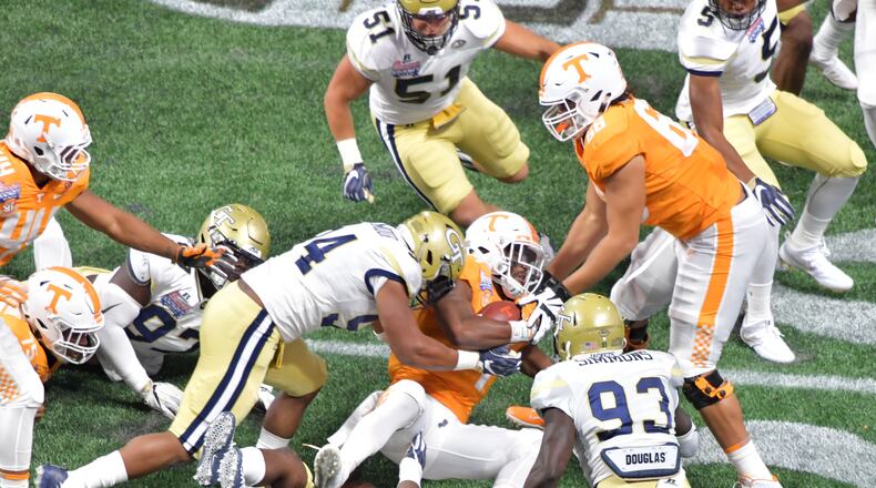 Tennessee running back John Kelly (4) gets tackled by Georgia Tech defensive lineman Anree Saint-Amour (94) and Georgia Tech linebacker Victor Alexander (9) at Mercedes-Benz Stadium on Monday, September 4, 2017. HYOSUB SHIN / HSHIN@AJC.COM