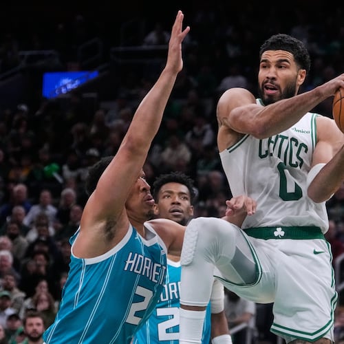 Boston Celtics forward Jayson Tatum (0) looks to pass while covered by Charlotte Hornets forward Grant Williams (2) during the second half of a NBA basketball game, Tuesday, April 7, 2026, in Boston. (AP Photo/Charles Krupa)