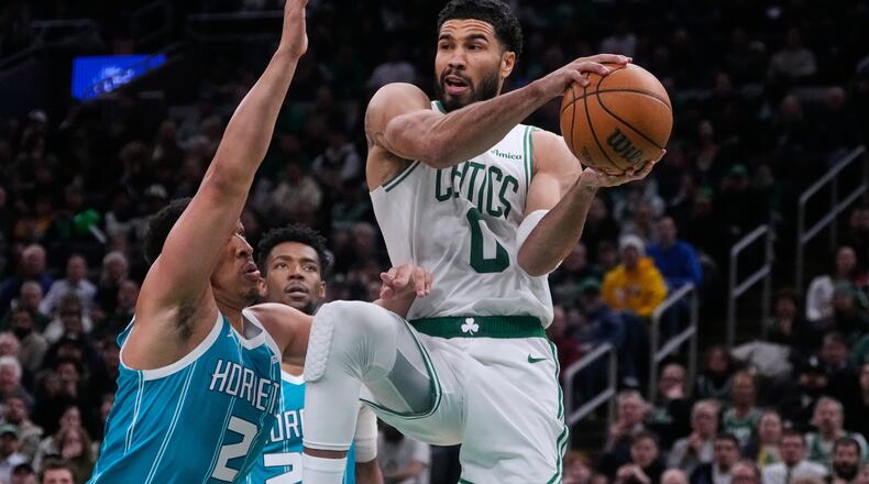 Boston Celtics forward Jayson Tatum (0) looks to pass while covered by Charlotte Hornets forward Grant Williams (2) during the second half of a NBA basketball game, Tuesday, April 7, 2026, in Boston. (AP Photo/Charles Krupa)