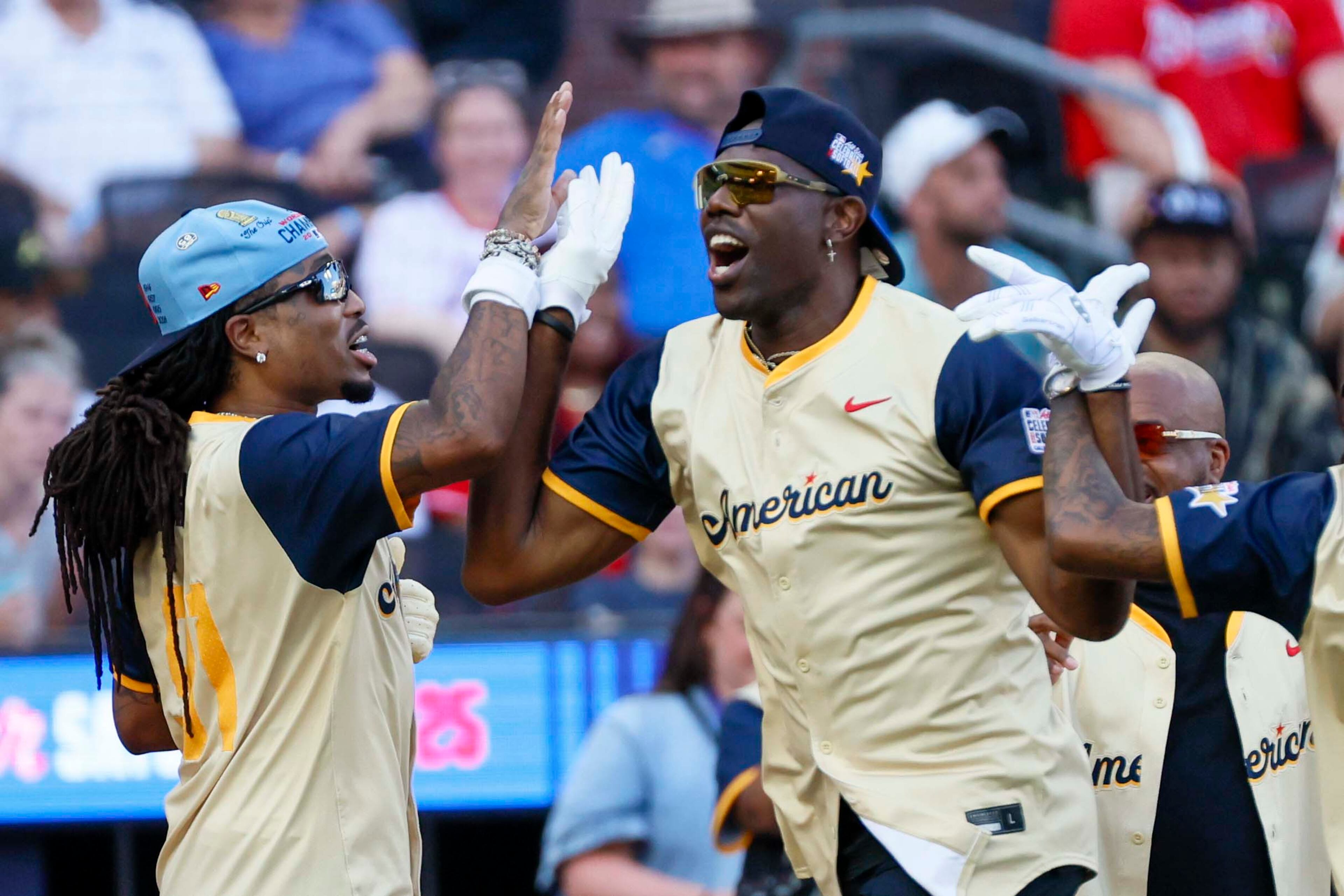 Quavo, a 4x GRAMMY-nominated rapper, celebrates with Terrell Owens, a Pro Football Hall of Famer, after hitting a grand slam during the MLB All-Star Celebrity Game at Truist Park on Saturday, July 12, 2025, in Atlanta.
(Miguel Martinez/ AJC)