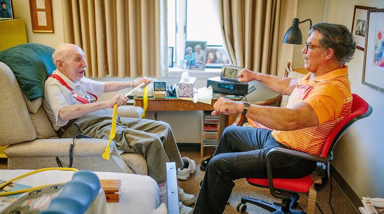 Wellness coach Michael Majoris, right, works with Melvin Judkis, doing exercises in Mr. Judkis apartment. Mr. Judkis, who is in his late 90s, has been working with Mr. Majoris twice a week. (Andrew Rush/Pittsburgh Post-Gazette/TNS)