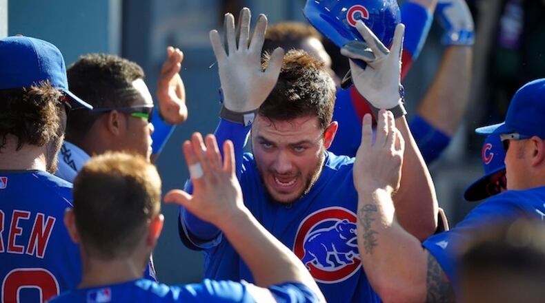 Chicago Cubs' Kris Bryant, center, is congratulated by teammates after hitting a two-run home run during the first inning of a baseball game against the Los Angeles Dodgers, Sunday, Aug. 30, 2015, in Los Angeles. (AP Photo/Mark J. Terrill)
