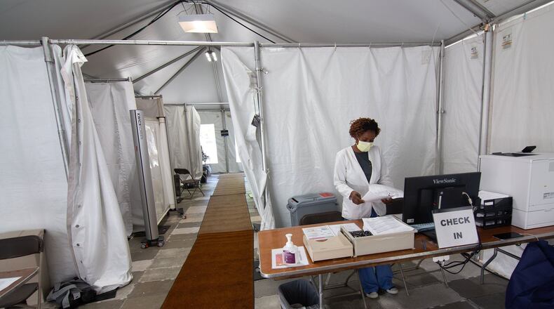 Northside Hospital technician Mamie Johnson prepares for patients in newly constructed tents outside of the hospital’s Emergency Department entrance on Monday. STEVE SCHAEFER/SPECIAL TO THE AJC