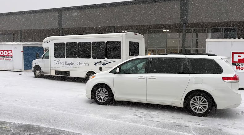 A van and a bus idle in front of Frontline Response International, one of the warming shelters run by DeKalb County, Georgia, on Tuesday, January 21, 2025. The county was transporting residents in need of shelter. (Photo Courtesy of Allen Siegler / Healthbeat)