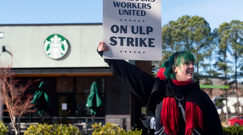 Cory Stepping, a barista, protests outside the Starbucks on Haynes Bridge Road in Alpharetta on Tuesday. She said she loves the job but believes she and her co-workers deserve better pay. (Ben Hendren for the Atlanta Journal-Constituion)