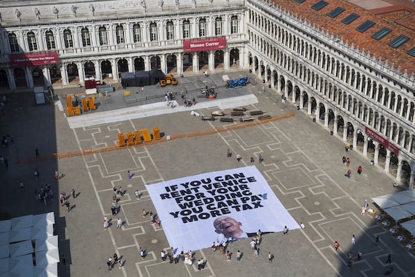 This photo released by Greenpeace shows a large banner against Amazon founder Jeff Bezos' planned wedding, in St. Mark Square, in Venice, Italy Monday, June 23, 2025. (Greenpeace via AP)