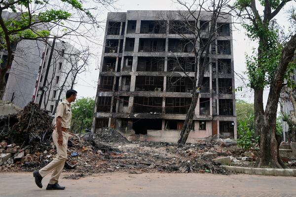 A policeman walks past buildings damaged in the June 12 Air India plane crash in Ahmedabad, India, Saturday, July 12, 2025. (AP Photo/Ajit Solanki)