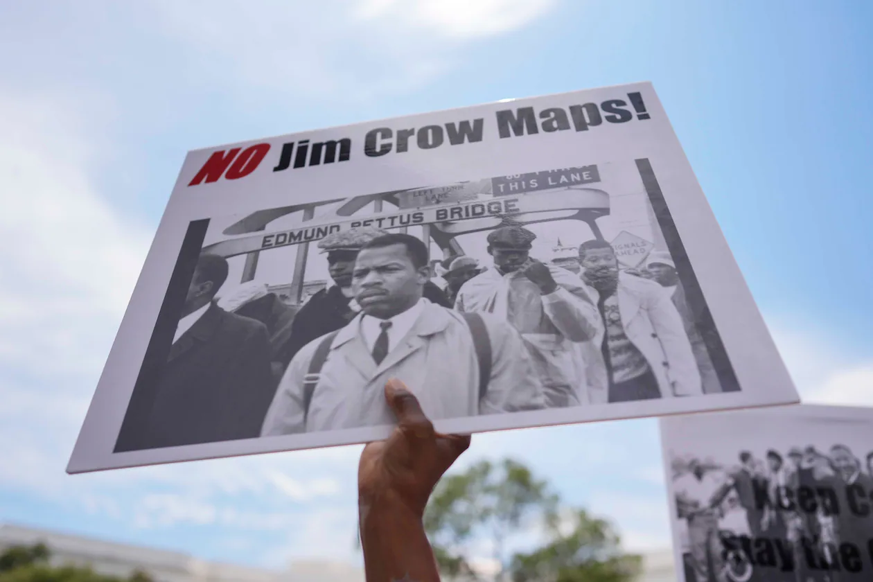 A protester holds a sign of the late Georgia Congressman John Lewis during a voting rally on Saturday, May 16, 2026, in Montgomery, Ala. (Mike Stewart/AP)