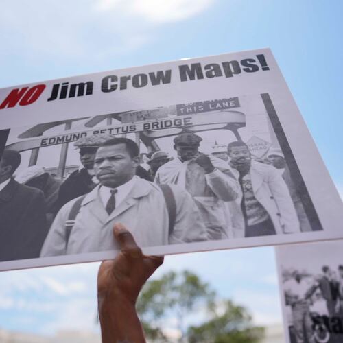 A protester holds a sign of the late Georgia Congressman John Lewis during a voting rally May 16, 2026, in Montgomery, Ala. (Mike Stewart/AP)