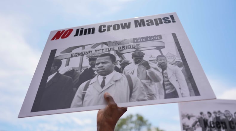 A protester holds a sign of the late Georgia Congressman John Lewis during a voting rally May 16, 2026, in Montgomery, Ala. (Mike Stewart/AP)