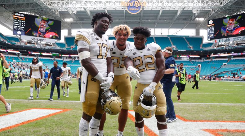 Georgia Tech linebacker Demetrius Knight II (17) defensive lineman Sylvain Yondjouen (32) and running back Jamious Griffin (22) pose as they celebrate after an NCAA college football game against Miami, Saturday, Oct. 19, 2019, in Miami Gardens, Fla. Georgia Tech defeated Miami 28-21 in overtime. (AP Photo/Wilfredo Lee)