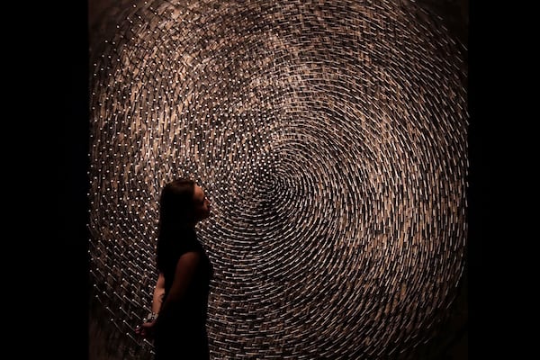 FILE - A Christie's auction house employee poses for photographs next to one part of German Sculptor's Guenther Uecker's "Spirale I, Spirale II (Doppelspirale)" at their premises in London, Friday, March 3, 2017. (AP Photo/Matt Dunham, File)