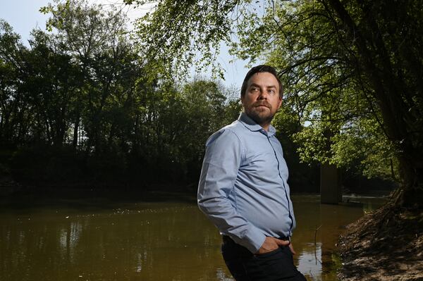 Jesse Demonbreun-Chapman, executive director and riverkeeper for the Coosa River Basin Initiative, stands by the Coosawattee River. His group sued the city of Calhoun over PFAS contamination in the municipal water system, alleging sludge with forever chemicals polluted local water. (Hyosub Shin/AJC) 