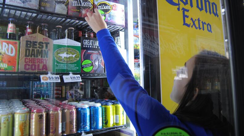 Fairfield High School Youth Coalition member Lindsey Ollis affixes warning labels to multipack containers of beer and wine coolers at Dixie Foodmart on Ohio 4 in Fairfield Sunday, March 20, 2016. The effort was the first installment in 2-day Sticker Shock initiative launched by Coalition for a Safe and Drug-Free Fairfield to educate the public and change attitudes about buying for and serving alcohol to anyone under the age of 21. ERIC SCHWARTZBERG/STAFF