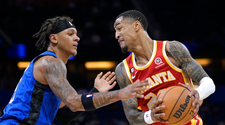 Atlanta Hawks forward John Collins, right, is defended by Orlando Magic forward Paolo Banchero (5) during the first half of an NBA basketball game Wednesday, Nov. 30, 2022, in Orlando, Fla. (AP Photo/Phelan M. Ebenhack)