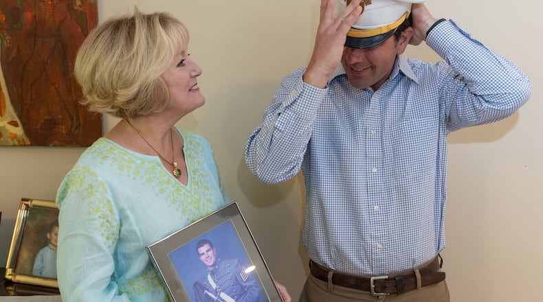 Heidi Hetzler watches as Greg Ambrosia tries on his hat when they met for the first time after she returned the hat he wore for graduation from West Point in 2005. He threw his hat at the graduation ceremony never expecting to see it back. But recently Heidi found it cleaning her son's room. PHIL SKINNER FOR THE ATLANTA JOURNAL-CONSTITUTION