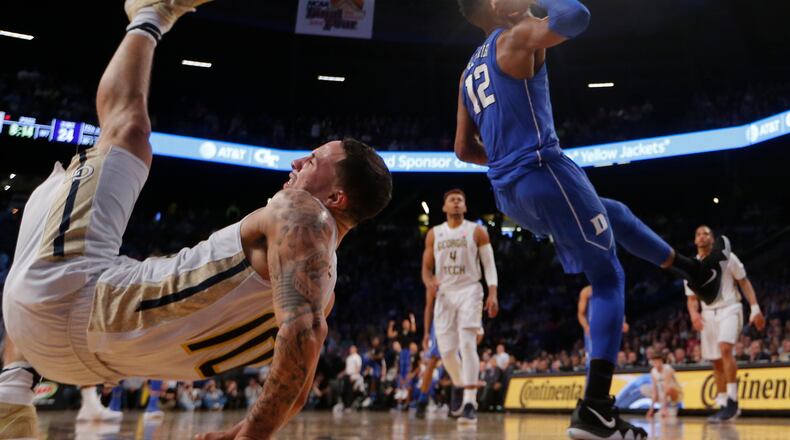 Georgia Tech guard Jose Alvarado (10) falls to the floor after battling Duke forward Javin DeLaurier (12) during an NCAA college basketball game Sunday, Feb. 11, 2018, in Atlanta. Alvarado injured his arm and left the game. (AP Photo/John Bazemore)