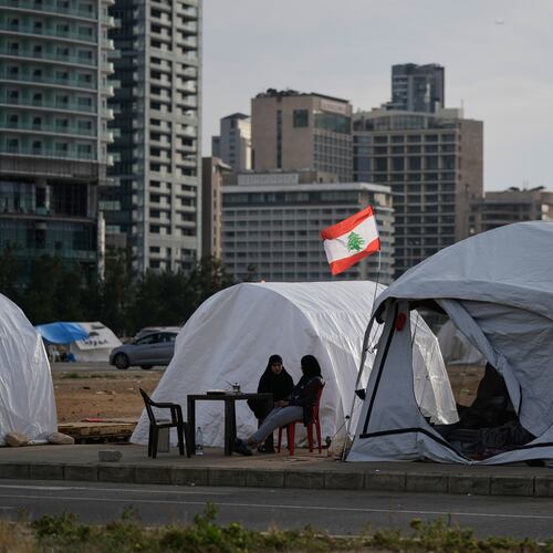 Displaced people who fled Israeli strikes in southern Lebanon sit outside shelter tents in Beirut, April 24, 2026. (AP Photo/Bilal Hussein)