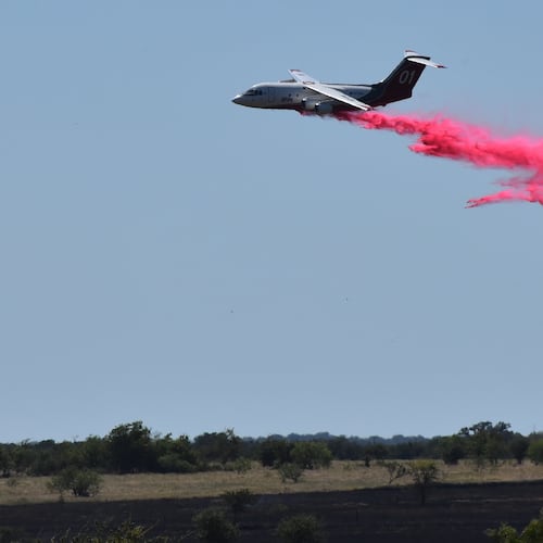 A tanker aircraft dumps fire retardant on a field southwest of Salado, Texas, Wednesday, Aug. 12, 2026, after a military helicopter crashed and sparked a grass fire. (Brent Johnson/The Killeen Daily Herald via AP)