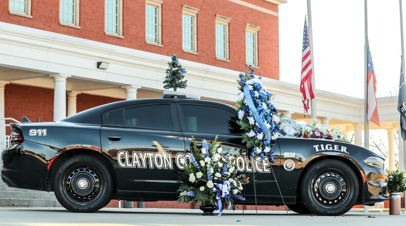 Flowers adorn a Clayton County police vehicle in December after the death of Henry Laxson, a Clayton field training officer killed in the line of duty. (John Spink / John.Spink@ajc.com)
