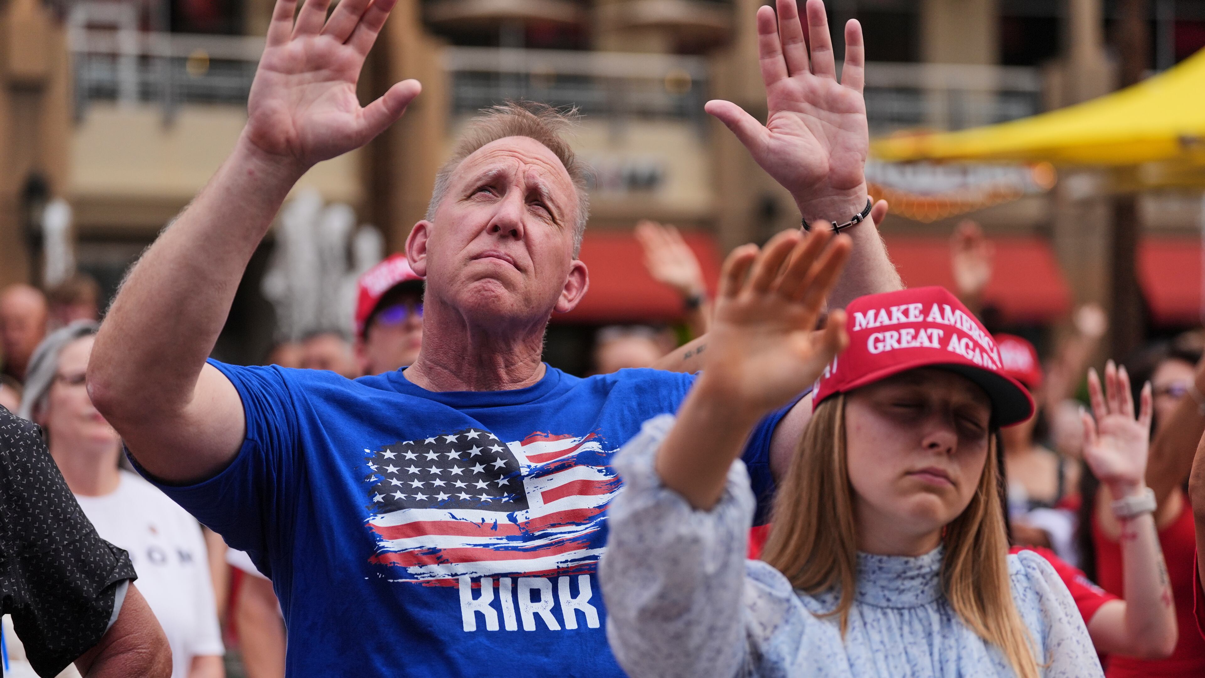 People listen to a worship song in the overflow area outside before a memorial for conservative activist Charlie Kirk, Sunday, Sept. 21, 2025, at State Farm Stadium in Glendale, Ariz. (AP Photo/Jae C. Hong)