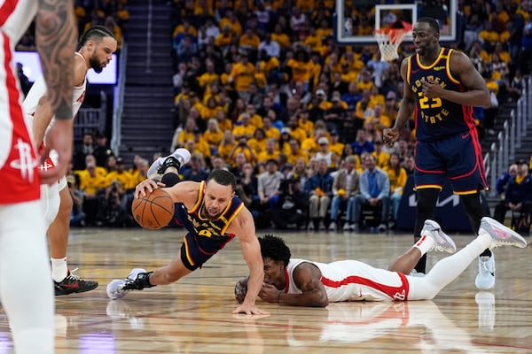 Golden State Warriors guard Stephen Curry (30) falls after colliding with Houston Rockets forward Dillon Brooks, second from left, during the first half of Game 4 of an NBA basketball first-round playoff series Monday, April 28, 2025, in San Francisco. (AP Photo/Godofredo A. Vásquez)