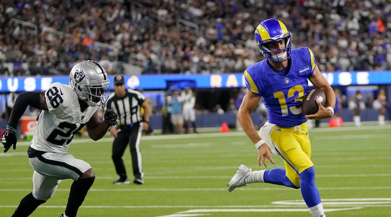 Los Angeles Rams quarterback Stetson Bennett, right, runs for a touchdown past Las Vegas Raiders safety Jaquan Johnson during the second half of a preseason NFL football game Saturday, Aug. 19, 2023, in Inglewood, Calif. (AP Photo/Mark J. Terrill)