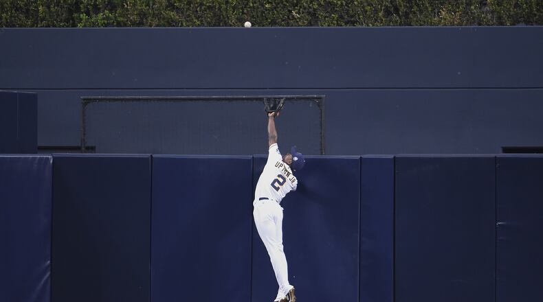 Melvin Upton Jr. of the San Diego Padres goes over the wall to take away a home run from J.J. Hardy #2 of the Baltimore Orioles. (Photo by Denis Poroy/Getty Images)