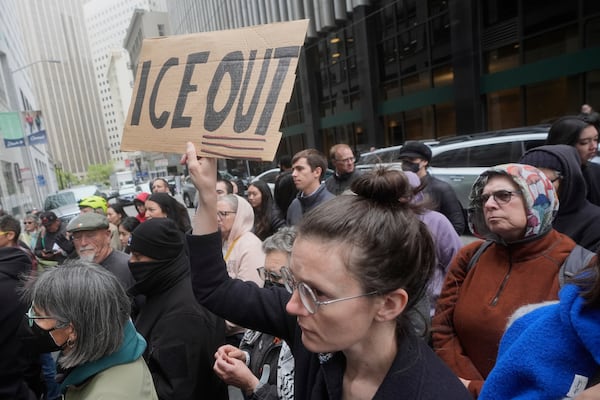 A person holds up a sign during a news conference and rally by immigrant justice organizations and advocates protesting ICE arrests in San Francisco, Wednesday, May 28, 2025. (AP Photo/Jeff Chiu)