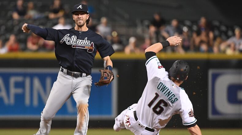 Braves’ Dansby Swanson turns the double play over Arizona’s Chris Owings during the seventh inning Sept. 6, 2018, at Chase Field in Phoenix.