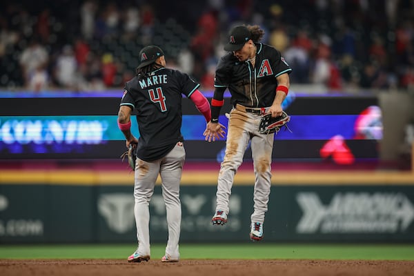 Arizona Diamondbacks second baseman Ketel Marte (4) and outfielder Alek Thomas, right, celebrate after a win against the Atlanta Braves, Wednesday, June 4, 2025, in Atlanta. (AP Photo/Colin Hubbard)