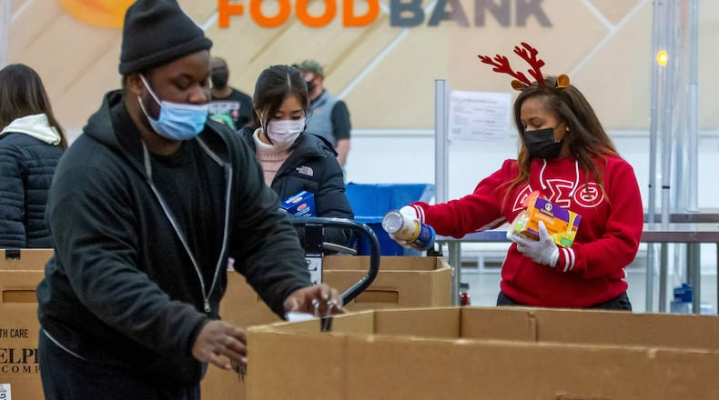 Volunteer Honour Wai Williams (R) sorts food into their appropriate boxes at the Atlanta Community Food Bank Thursday, 23, 2021. STEVE SCHAEFER FOR THE ATLANTA JOURNAL-CONSTITUTION