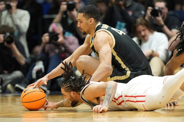 Houston's Emanuel Sharp, bottom, and Purdue's Trey Kaufman-Renn dive after a loose ball during the second half in the Sweet 16 of the NCAA college basketball tournament Friday, March 28, 2025, in Indianapolis. (AP Photo/AJ Mast)