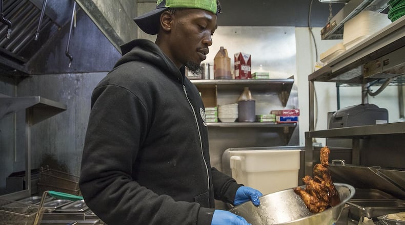 Line cook Royree Collins prepares smoked chicken wings at Fox Bros. Bar-B-Q near Atlanta’s Little Five Points community. They expect to sell roughly 18,000 wings on game day at that location. ALYSSA POINTER / ALYSSA.POINTER@AJC.COM