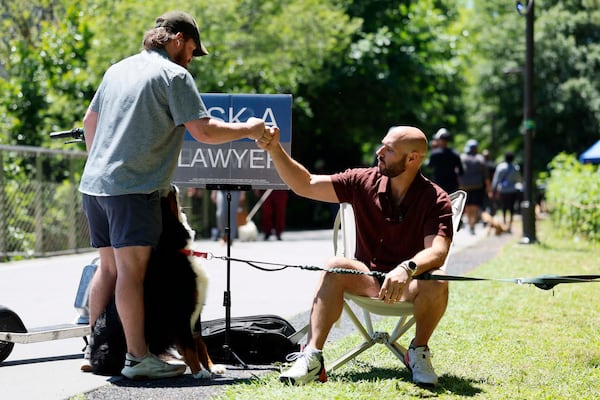 A Beltline visitor pauses to greet Atlanta attorney Cody Randall and his 6-year-old Bernese Mountain Dog, Reba, on Sunday, May 3, 2026. Randall says "anyone and everyone" approaches him with questions, both personal and general, now that he's a social media star with 1.5 million followers. (Miguel Martinez/AJC)