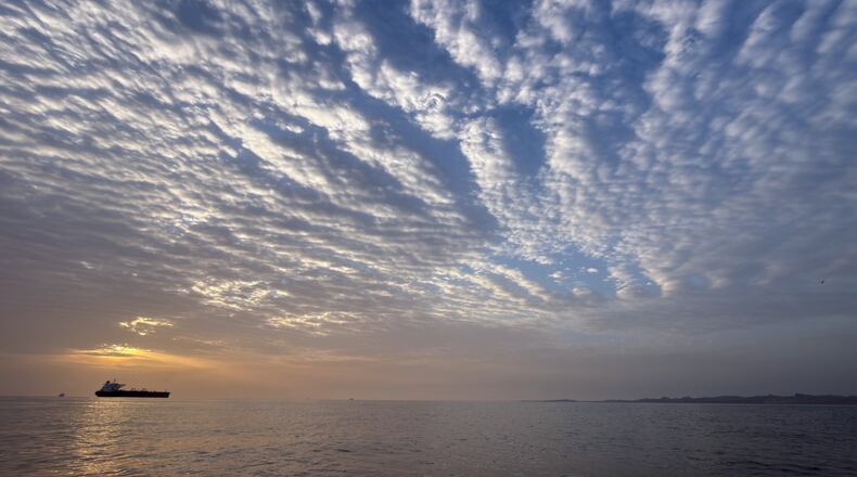 The sun rises behind a tanker anchored in the Strait of Hormuz off the coast of Qeshm Island, Iran, Saturday, April 18, 2026. (AP Photo/Asghar Besharati)