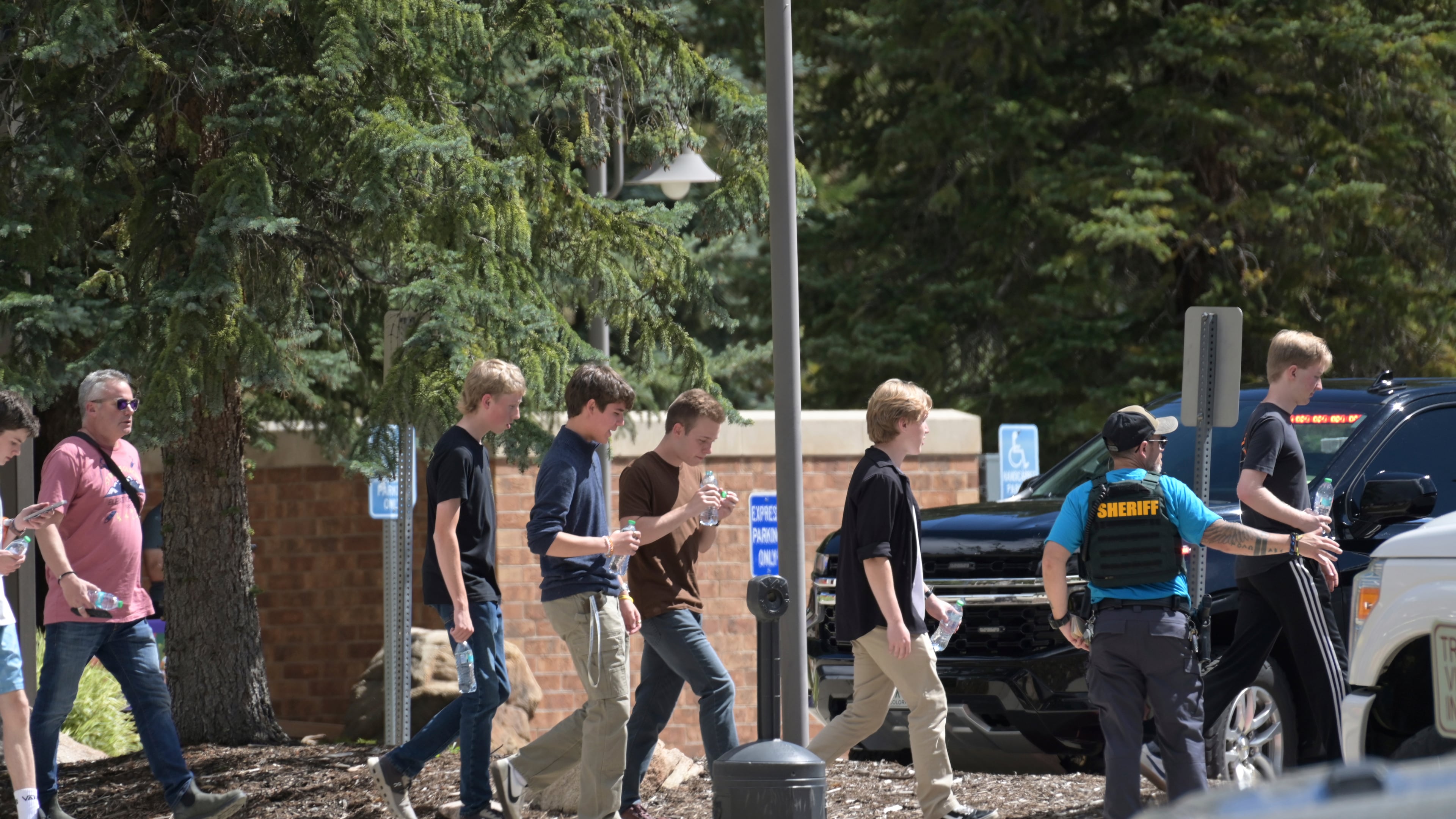 Students walk to board a bus amid heavy police presence at the Evergreen Library after a shooting at Evergreen High School in Evergreen, Colo., on Wednesday, Sept. 10, 2025. (Hyoung Chang/The Denver Post via AP)