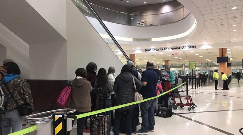 Shortly after power was restored at much of Atlanta's airport on Sunday night, people began lining up at the security checkpoint.