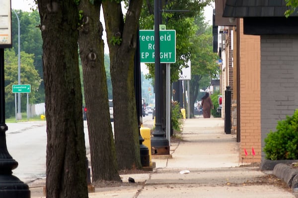 In this image made from video, a pedestrian walks in the distance Monday, June 9, 2025, in Dearborn, Mich. (AP Photo/Mike Householder)