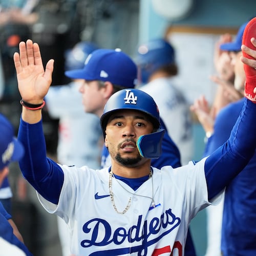 Los Angeles Dodgers' Mookie Betts celebrates in the dugout after scoring against the Milwaukee Brewers during the first inning in Game 4 of baseball's National League Championship Series, Friday, Oct. 17, 2025, in Los Angeles. (AP Photo/Ashley Landis)