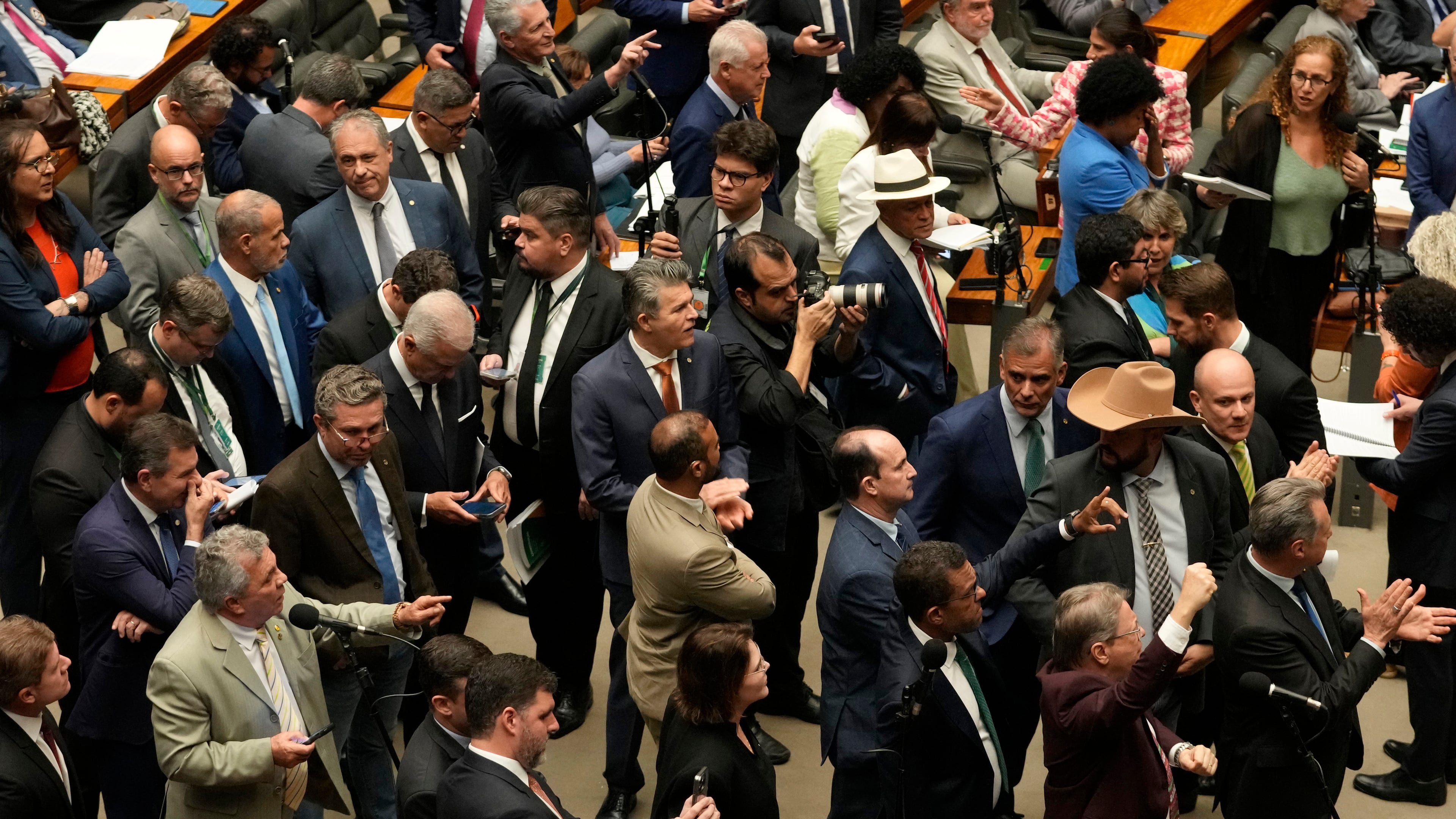 Congresspeople from parties supporting former President Jair Bolsonaro, sentenced for leading a coup attempt, attend a session to consider a bill to alter sentencing guidelines for certain crimes including coups d'état, in Brasilia, Brazil, Tuesday, Dec. 9, 2025. (AP Photo/Eraldo Peres)