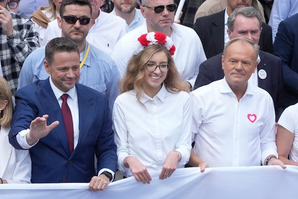 The liberal presidential candidate Rafal Trzaskowski, front left, waves as he and Polish prime minister Donald Tusk, front right, take part in a march one week ahead of a decisive presidential election in Warsaw, Poland on Sunday, May 25, 2025. (AP Photo/Czarek Sokolowski)