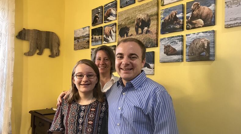 Megan Sorbo, left, with her mother, Tina, and brother, Trevor, at the family’s home near Orlando. The bear photographs on the wall were taken by Megan’s mom during a vacation to Katmai National Park and Preserve in Alaska. (Stephen Hudak/Orlando Sentinel/TNS)