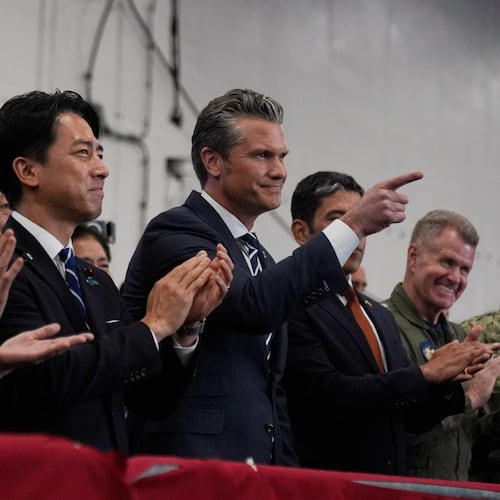 U.S. Defense Secretary Pete Hegseth, center right, with Japanese Prime Minister Sanae Takaichi, left, and Defense Minister Shinjiro Koizumi, gestures as they listen to President Donald Trump speak to members of the military aboard the USS George Washington, an aircraft carrier docked at an American naval base, in Yokosuka, south of Tokyo, Tuesday, Oct. 28, 2025. (AP Photo/Mark Schiefelbein)