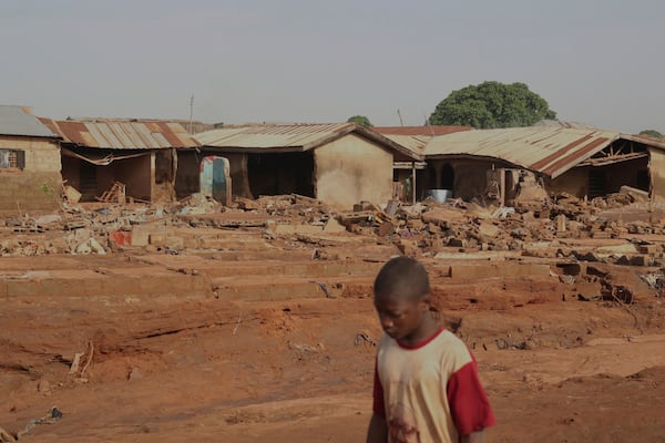 FILE - A boy walks past a flooded area after heavy rainfall in the market town of Mokwa, north-central Nigeria, Saturday May 31, 2025. (AP Photo/Usman Salihu Mokwa), File)